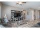 Open-concept living room featuring coastal decor, a ceiling fan, and an entertainment center at 15233 W Baden St, Goodyear, AZ 85338