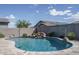 Beautifully designed backyard pool with boulder waterfall and travertine tile at 15233 W Baden St, Goodyear, AZ 85338