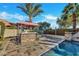 Outdoor kitchen area featuring a built-in grill and stone bar top adjacent to the pool area with stone paver flooring at 15837 W Bonitos Dr, Goodyear, AZ 85395