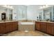 Elegant bathroom with dual vanities, a tiled soaking tub, and decorative tile accents at 15837 W Bonitos Dr, Goodyear, AZ 85395