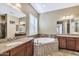 Bathroom showcasing dual sinks, granite countertops, and a separate soaking tub with tiled surround at 15837 W Bonitos Dr, Goodyear, AZ 85395