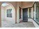 Inviting front porch featuring tile flooring, arched entry, and detailed door trim at 15837 W Bonitos Dr, Goodyear, AZ 85395