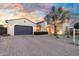 Home featuring a wide driveway, desert landscaping, and a charming facade under a colorful sky at 15837 W Bonitos Dr, Goodyear, AZ 85395