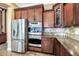 Gourmet kitchen with stainless steel appliances and warm wood cabinetry at 15837 W Bonitos Dr, Goodyear, AZ 85395