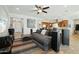 Spacious living room featuring a large couch, tiled floors, and seamless transition into the kitchen at 15837 W Bonitos Dr, Goodyear, AZ 85395