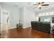 Cozy living room with hardwood floors, ceiling fan, and built-in entertainment center at 15837 W Bonitos Dr, Goodyear, AZ 85395