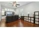 Cozy living room with wood floors, a large sectional, built-in cabinets, and plantation shutters at 15837 W Bonitos Dr, Goodyear, AZ 85395