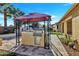 An outdoor kitchen under a canopy with a grill, and pizza oven against a sunny blue sky at 15837 W Bonitos Dr, Goodyear, AZ 85395