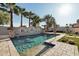 Backyard pool with in-ground lighting, a waterfall feature, and surrounded by artificial turf and desert landscaping at 15837 W Bonitos Dr, Goodyear, AZ 85395