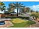 Backyard putting green surrounded by mature trees and greenery, offering a private recreational space at 15837 W Bonitos Dr, Goodyear, AZ 85395