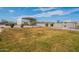 Sprawling backyard with a green lawn, mature landscaping, gazebo and metal shed under blue skies at 1612 N 201St Ave, Buckeye, AZ 85396