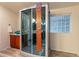 Contemporary bathroom showcasing a walk-in shower with a glass enclosure, vanity and glass block window at 1612 N 201St Ave, Buckeye, AZ 85396