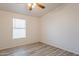 Bedroom with ceiling fan and light-colored wood-look floors. Natural light from the window at 1612 N 201St Ave, Buckeye, AZ 85396