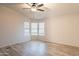 Comfortable bedroom with bay windows, ceiling fan, and stylish wood-look floors enhancing its appeal at 1612 N 201St Ave, Buckeye, AZ 85396