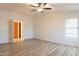 Open bedroom with wood-look floors, ceiling fan, and a doorway leading to the closet or attached bath at 1612 N 201St Ave, Buckeye, AZ 85396