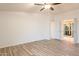 Spacious bedroom with ceiling fan and wood-look floors leading to an attached bathroom with glass shower at 1612 N 201St Ave, Buckeye, AZ 85396