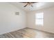 Bright bedroom features wood-look flooring, a ceiling fan, and a window that provides ample natural light at 1612 N 201St Ave, Buckeye, AZ 85396