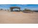 Wide open land featuring a metal shed and solar panels under a clear, blue sky at 1612 N 201St Ave, Buckeye, AZ 85396