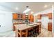 Bright kitchen featuring wood cabinets, granite counters, modern appliances, a skylight and center island with bar seating at 1612 N 201St Ave, Buckeye, AZ 85396