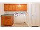 Laundry room features wood cabinets, gray countertop and white appliances at 1612 N 201St Ave, Buckeye, AZ 85396