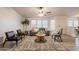 Bright living room with a gray sofa, wood-look floors, and a ceiling fan at 1612 N 201St Ave, Buckeye, AZ 85396