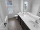 Well-lit bathroom features double sinks with dark wood cabinets and a shower-tub combination at 16472 W Tether Trl, Surprise, AZ 85387