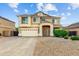 Two-story home with a two-car garage, desert landscaping, and a covered front porch at 16585 W Harrison St, Goodyear, AZ 85338