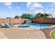 Backyard oasis with a pool, water feature, blue umbrella, and lounge chairs at 16585 W Harrison St, Goodyear, AZ 85338