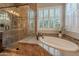 Bright bathroom boasting a large bathtub, walk-in shower, and a shuttered window; finished with stylish mosaic tile accents at 1697 E Tangelo Pl, Queen Creek, AZ 85140