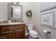 Charming half-bathroom with stylish decor, dark wood vanity, and unique wall art at 1697 E Tangelo Pl, Queen Creek, AZ 85140