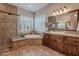 The bathroom is finished with tile and features a glass-enclosed shower, tub, large window, and vanity at 1697 E Tangelo Pl, Queen Creek, AZ 85140