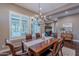 Elegant dining room with a dark wood table, chandelier, and plantation shutters at 1697 E Tangelo Pl, Queen Creek, AZ 85140