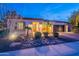 Inviting home at dusk, showcasing a well-manicured yard, landscape lighting, and a brick driveway at 1697 E Tangelo Pl, Queen Creek, AZ 85140