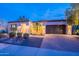 Inviting home at dusk, showcasing a well-manicured yard, landscape lighting, and a brick driveway at 1697 E Tangelo Pl, Queen Creek, AZ 85140