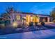 Charming single Gathering home with desert landscaping and exterior lighting at dusk at 1697 E Tangelo Pl, Queen Creek, AZ 85140