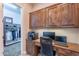 This office area features dark, wood cabinets, desktop, and a black office chair; it is adjacent to a walk-in closet at 1697 E Tangelo Pl, Queen Creek, AZ 85140