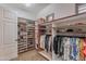 A large walk-in closet is furnished with shelving for shoes, hats, and handbags, as well as hanging rods for garments at 1697 E Tangelo Pl, Queen Creek, AZ 85140