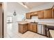 Open-concept kitchen featuring wood cabinets, stainless steel appliances, and tile floors at 1750 E Ocotillo Rd # 11, Phoenix, AZ 85016