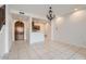 Bright living room with tile flooring, staircase access, and arched doorway leading to the kitchen at 1750 E Ocotillo Rd # 11, Phoenix, AZ 85016