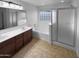 Bathroom with a tub, glass shower, and double sinks at 17699 W Tonto St, Goodyear, AZ 85338