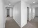 A carpeted hallway featuring white walls and several doors that offer a sense of privacy and separation at 17699 W Tonto St, Goodyear, AZ 85338