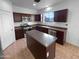 Kitchen with a center island, stainless steel appliances, and dark cabinetry at 17699 W Tonto St, Goodyear, AZ 85338