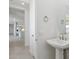 Powder room featuring a modern pedestal sink and mirror, as well as a view into the house at 17712 W Hatcher Rd, Waddell, AZ 85355