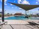 Community swimming pool featuring a splash pad, lounge chairs, and shade structures on a bright day at 17729 W Amber Dr, Goodyear, AZ 85338