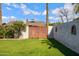 Backyard featuring lush green grass, mature trees, and a charming wooden gate at 1812 W Curry Drive Dr, Chandler, AZ 85224