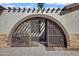 Close-up of a home's gated courtyard featuring desert landscaping and an arched entrance at 1812 W Curry Drive Dr, Chandler, AZ 85224