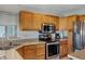 Functional kitchen with wooden cabinets, granite countertops, and stainless steel appliances at 1812 W Curry Drive Dr, Chandler, AZ 85224