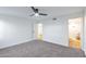 Well-lit bedroom with carpet, white walls, and entrance to bathroom at 18811 N 19Th Ave # 2025, Phoenix, AZ 85027