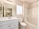 A bright bathroom featuring a vanity with a sink, a toilet, and a bathtub with a shower at 19802 N Greenview Dr, Sun City West, AZ 85375