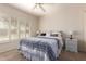 A bedroom featuring a large bed, tan carpet, white walls, and large windows with shutters at 19802 N Greenview Dr, Sun City West, AZ 85375